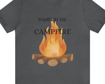 May include: A dark gray t-shirt with the text "Master of the Campfire" and a cartoon image of a campfire with orange flames.