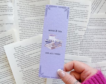 May include: A purple bookmark with a watercolor illustration of books, teacups, and lavender. The text "Books & Tea Are All I Need" is printed on the bookmark.