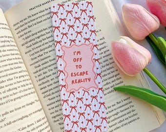 May include: A pink and white bookmark with red bows and the text "I'm off to escape reality".