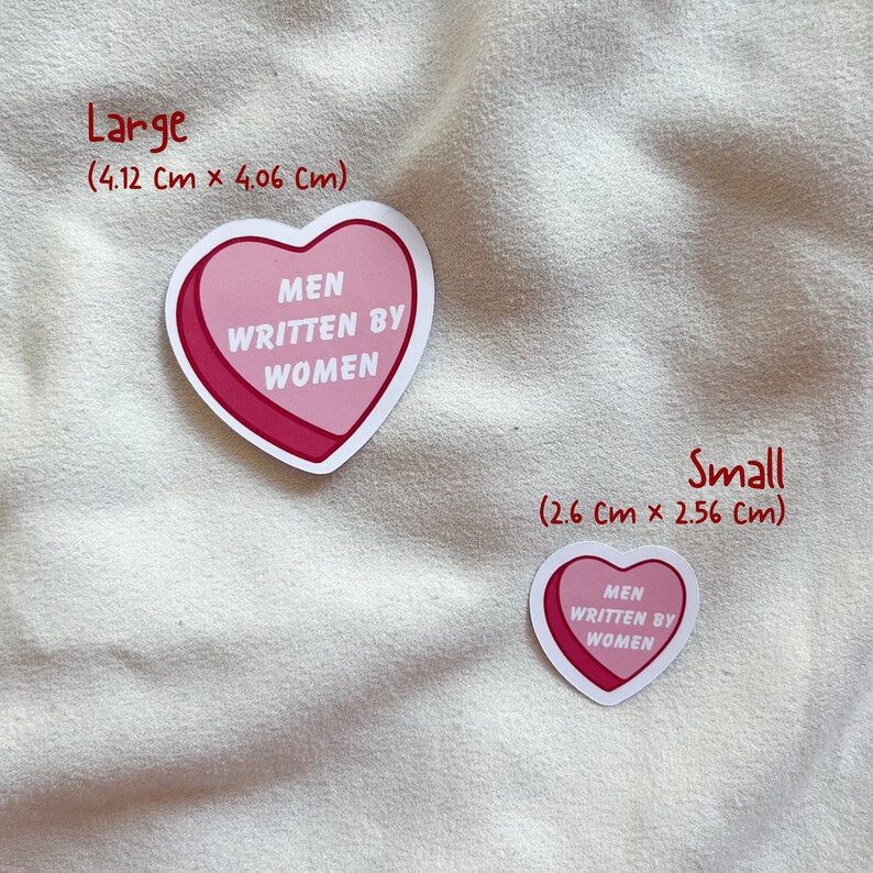 May include: Two pink heart-shaped stickers with the text "MEN WRITTEN BY WOMEN" in white. The larger sticker measures 4.12 cm by 4.06 cm and the smaller sticker measures 2.6 cm by 2.56 cm.