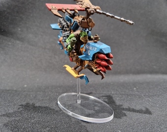 May include: A blue and yellow miniature spaceship with red rockets, a green figure, and the text "ROKKITZ" on the side.