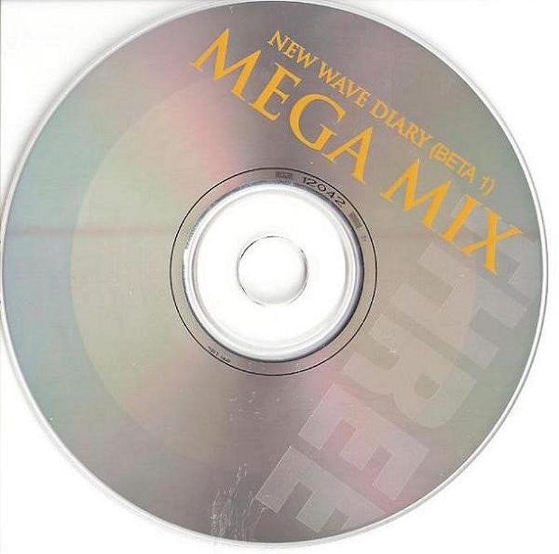 May include: A silver CD with the text "NEW WAVE DIARY (BETA 1)" and "MEGA MIX" in yellow lettering. The text "FREE" is printed vertically in yellow on the right side of the disc.