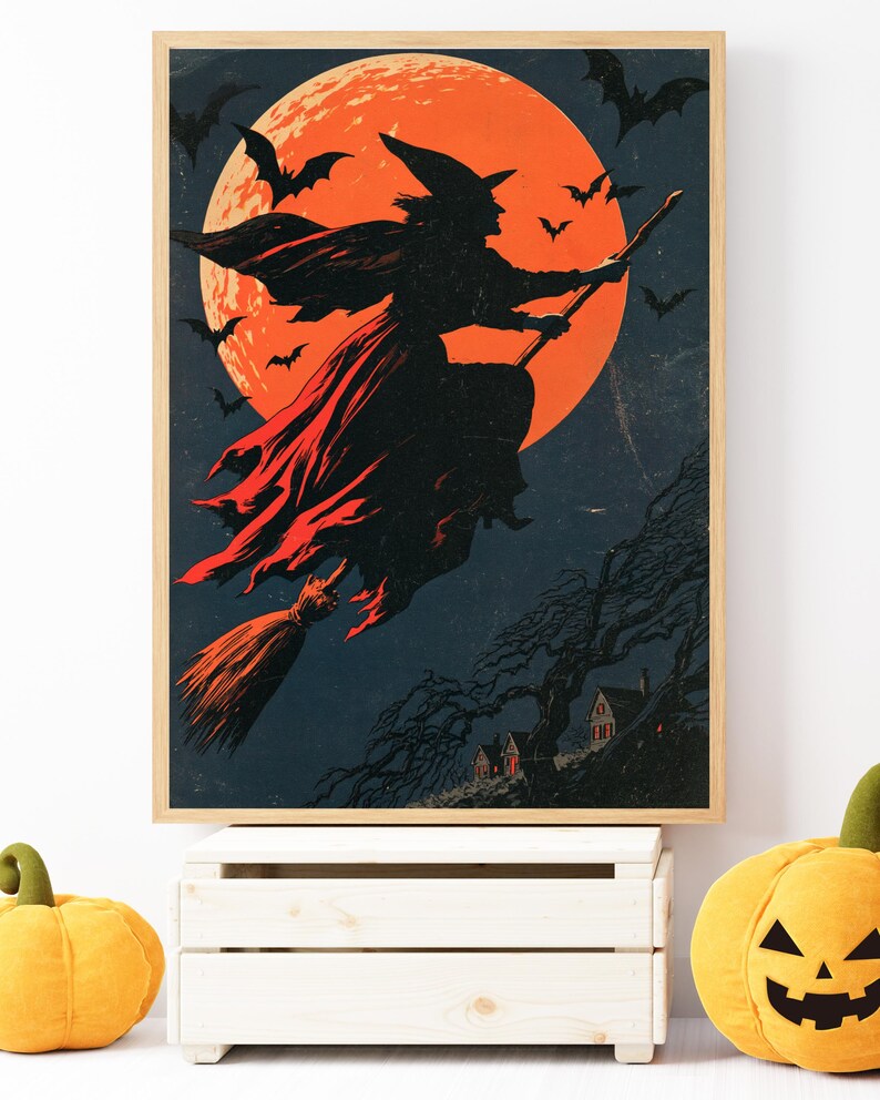 K&ouml;nnte beinhalten: Ein gerahmter Kunstdruck mit der Silhouette einer Hexe, die auf einem Besen vor einem gro&szlig;en, leuchtend orangefarbenen Vollmond fliegt. Der dunkle Nachthimmel ist voller fliegender Flederm&auml;use und ein kleines Haus steht zwischen kahlen B&auml;umen.