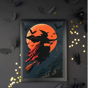 K&ouml;nnte beinhalten: Ein gerahmter, rechteckiger Wandkunstdruck mit der schwarzen Silhouette einer Hexe, die auf einem Besen vor einem gro&szlig;en, leuchtend orangefarbenen Vollmond fliegt. Die Szene zeigt kleine schwarze Flederm&auml;use und eine dunkle Landschaft.