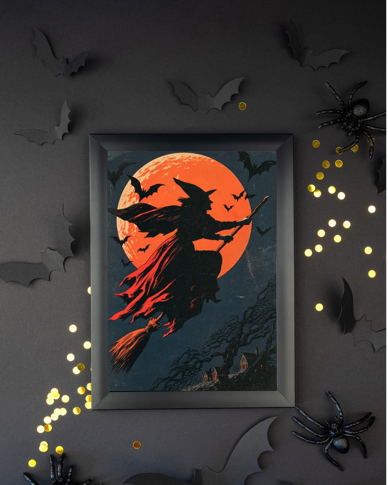 K&ouml;nnte beinhalten: Ein gerahmter, rechteckiger Wandkunstdruck mit der schwarzen Silhouette einer Hexe, die auf einem Besen vor einem gro&szlig;en, leuchtend orangefarbenen Vollmond fliegt. Die Szene zeigt kleine schwarze Flederm&auml;use und eine dunkle Landschaft.