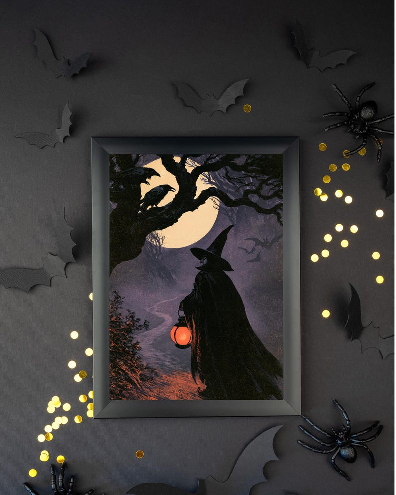 Peut inclure: Un cadre rectangulaire noir contenant une impression repr&eacute;sentant une silhouette v&ecirc;tue d'une cape sombre et d'un chapeau pointu marchant sur un chemin nocturne. La silhouette tient une lanterne orange sous une pleine lune avec des corbeaux.