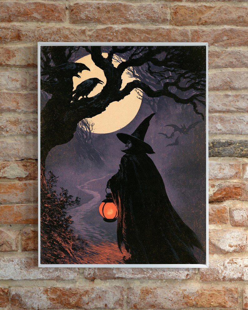 Peut inclure: Une impression d'art encadr&eacute;e repr&eacute;sentant une silhouette v&ecirc;tue d'une cape noire et d'un chapeau pointu sur un chemin nocturne. La silhouette tient une lanterne orange lumineuse. Une pleine lune, un arbre sombre et des chauves-souris sont visibles.