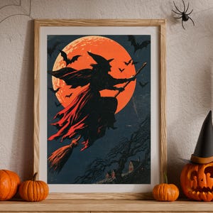 K&ouml;nnte beinhalten: Ein gerahmter Kunstdruck mit der Silhouette einer Hexe, die auf einem Besen vor einem gro&szlig;en, leuchtend orangefarbenen Vollmond fliegt. Der dunkelblaue Nachthimmel ist voller fliegender Flederm&auml;use und ein kleiner, dunkler, blattloser Baum steht &uuml;ber H&auml;usern.