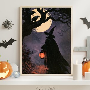 Peut inclure: Une impression d'art mural encadr&eacute;e repr&eacute;sentant une sorci&egrave;re v&ecirc;tue d'une cape noire et d'un chapeau pointu, tenant une lanterne orange lumineuse. La sc&egrave;ne montre un sentier forestier sombre sous une grande lune jaune avec deux corbeaux.