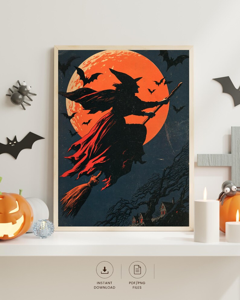 K&ouml;nnte beinhalten: Ein gerahmter Kunstdruck mit der Silhouette einer Hexe auf einem Besen vor einem gro&szlig;en orangefarbenen Vollmond. Die dunkle Szene zeigt fliegende Flederm&auml;use sowie eine Landschaft mit B&auml;umen und H&auml;usern. Der Druck steht auf einem wei&szlig;en Regal.