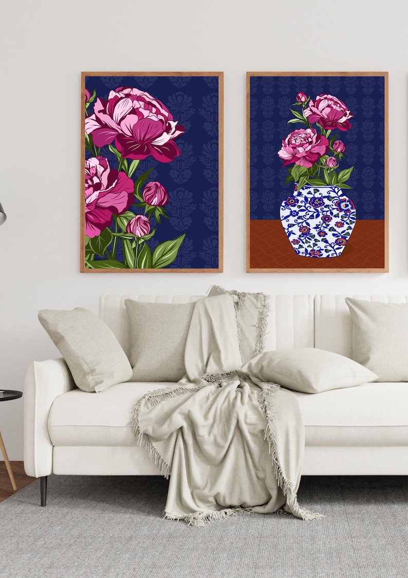 May include: Two framed wall art prints featuring vibrant magenta peonies against a dark blue patterned background. One print displays a cluster of flowers, while the other shows peonies in a blue and white floral patterned vase on a brown surface.