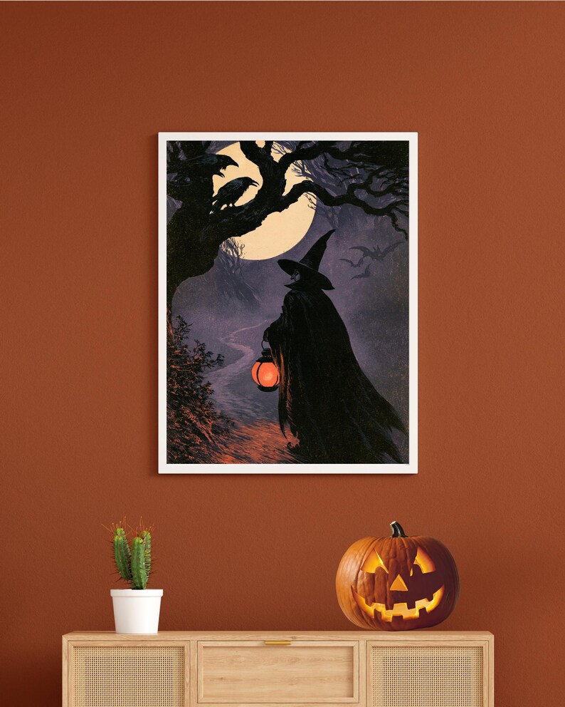 Peut inclure: Une impression d'art murale rectangulaire encadr&eacute;e repr&eacute;sentant une silhouette drap&eacute;e portant un chapeau pointu et tenant une lanterne orange lumineuse sur un chemin nocturne. La sc&egrave;ne montre une pleine lune, des arbres, des corbeaux et des chauves-souris.