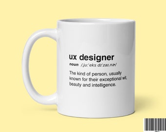 Op de afbeelding: Een witte keramische mok met een zwart ontwerp waarop "ux designer" staat en een definitie van de term. De definitie luidt: "zelfstandig naamwoord /ju:'eks dı'zaı.na/ Het soort persoon dat meestal bekend staat om zijn uitzonderlijke scherpzinnigheid, schoonheid en intelligentie."