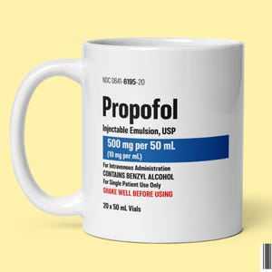 May include: White ceramic mug with the word "Propofol" printed in black. The mug also displays the text "500 mg per 50 mL" in a blue rectangle, along with other medical information. The mug has a white handle and is set against a yellow background.