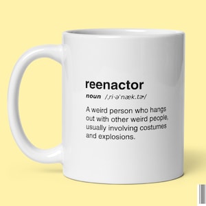 May include: White ceramic mug with a black definition of the word "reenactor" printed on it. The definition reads: "A weird person who hangs out with other weird people, usually involving costumes and explosions."