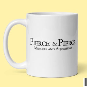 Könnte beinhalten: Weiße Keramik-Kaffeetasse mit einem schwarzen Logo, auf dem "Pierce & Pierce Mergers and Acquisitions" steht.