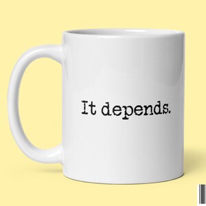 Pode incluir: Caneca de café de cerâmica branca com uma inscrição preta que diz "Depende."
