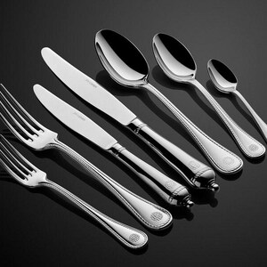 Puede incluir: Un juego de cubiertos de plata, que incluye un tenedor, un cuchillo y cucharas. Los cubiertos tienen un patrón decorativo en los mangos.