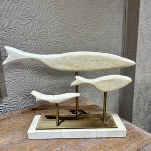 Op de afbeelding: Een set van drie keramische mokken met een gespikkelde, matte afwerking. De mokken zijn in tinten crème, lichtgrijs en donkergrijs. Elke mok heeft een eenvoudig, minimalistisch ontwerp.