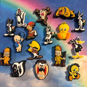 May include: A collection of fifteen colorful rubber shoe charms featuring various Looney Tunes characters including Bugs Bunny, Tweety Bird, Daffy Duck, Taz, Sylvester, Porky Pig, Speedy Gonzales, Elmer Fudd, Pepe Le Pew, and Marc Antony.