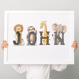 K&ouml;nnte beinhalten: Ein wei&szlig;er gerahmter Druck mit dem Namen "JOHN", der in schwarzen Buchstaben geschrieben ist. Jeder Buchstabe ist mit einem anderen Tier verziert: einem L&ouml;wen, einem Faultier, einer Giraffe und einem Elefanten.