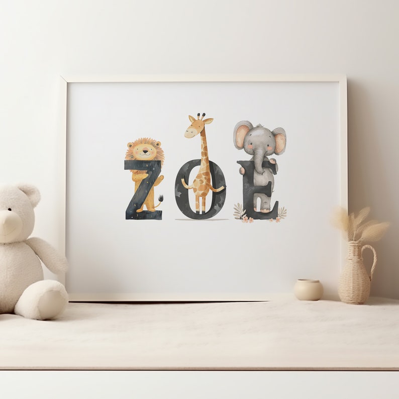 K&ouml;nnte beinhalten: Ein wei&szlig;er gerahmter Druck mit dem Namen "ZOE", der in schwarzen Buchstaben geschrieben ist. Jeder Buchstabe ist mit einem anderen Tier verziert: einem L&ouml;wen, einer Giraffe und einem Elefanten.