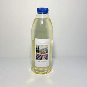 Peut inclure: Une bouteille en plastique transparente avec un bouchon bleu remplie d'un liquide jaune clair. L'étiquette présente une peinture de paysage d'un champ de lavande et le texte "HUILE ESSENTIELLE lavandin grosso".