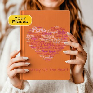 May include: Orange journal with the words "Your Places" in a yellow box. The cover features a heart-shaped design filled with travel destinations like Paris, London, and New York. The phrase "Journey Of The Heart" is printed at the bottom.