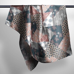 May include: A square scarf featuring a patchwork design with various geometric and floral patterns in shades of dusty rose, slate blue, white, and charcoal gray. The fabric displays repeating motifs including small circles, leaves, and squares.