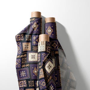 May include: Three rolls of fabric featuring a repeating pattern of geometric shapes, elephants, and floral designs in purple, black, and tan. The fabric is rolled around cardboard tubes.