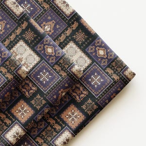May include: Folded fabric with a repeating geometric pattern in shades of purple, brown, and beige. The design features squares with intricate details, creating a textured appearance. The fabric appears to be woven.