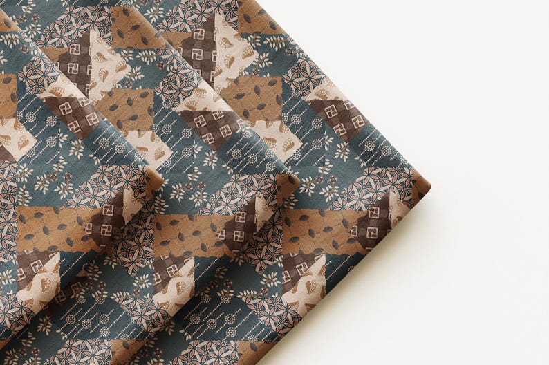 May include: A folded piece of fabric featuring a patchwork design in shades of dark teal, brown, and cream. The pattern consists of repeating geometric shapes, including small squares with swastika-like symbols, leaf motifs, and dotted lines.