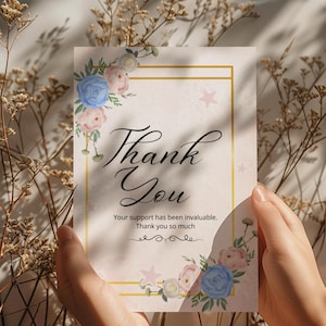 May include: A thank you card with floral accents and the words "Thank You." The card features a gold border, pink stars, and watercolor flowers in shades of blue and pink. The text "Your support has been invaluable. Thank you so much" is also included.