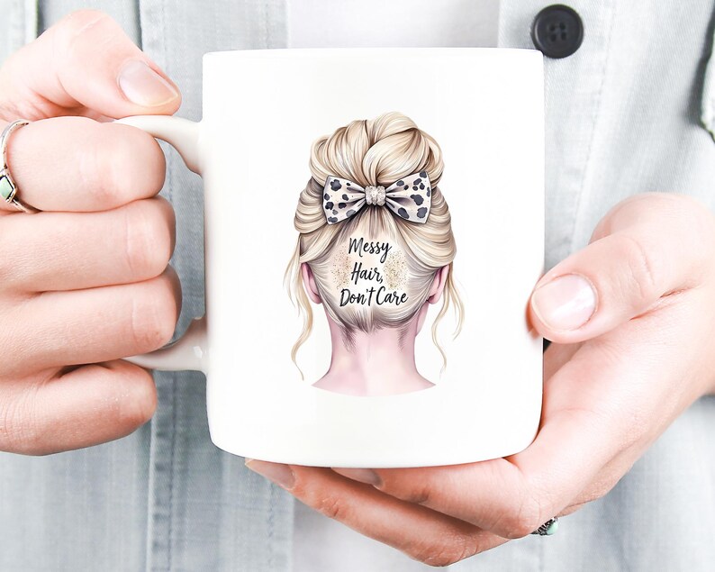K&ouml;nnte beinhalten: Wei&szlig;er Keramikbecher mit einer Illustration einer Hochsteckfrisur einer Frau und einer Schleife mit Leopardenmuster. Der Text "Messy Hair, Don't Care" ist auf dem Becher aufgedruckt. Der Becher wird von einer Person gehalten.