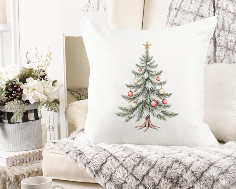 Puede incluir: Coj&iacute;n cuadrado blanco con un dise&ntilde;o de &aacute;rbol de Navidad en acuarela. El &aacute;rbol est&aacute; decorado con adornos rosas y blancos y coronado con una estrella dorada. El coj&iacute;n est&aacute; sobre una manta afelpada con estampado gris y blanco.