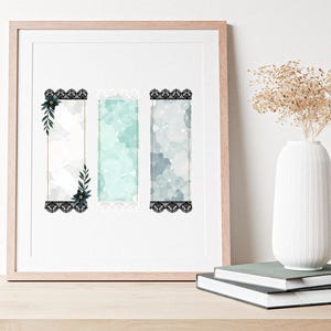 K&ouml;nnte beinhalten: Gerahmtes Kunstwerk mit drei vertikalen Aquarelltafeln und schwarzen Spitzenr&auml;ndern. Die Tafeln haben eine helle Farbpalette aus Wei&szlig;, T&uuml;rkis und Grau. Jede Tafel hat ein Blumendesign in den Ecken. Das Kunstwerk wird auf einer Holzoberfl&auml;che pr&auml;sentiert.