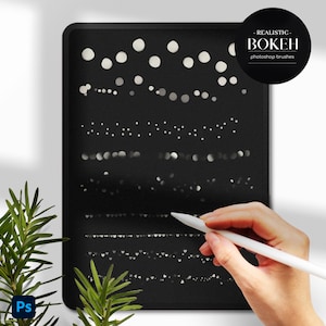 Op de afbeelding: Een zwart digitaal tabletscherm waarop verschillende Photoshop-penseelvormen worden weergegeven om realistische bokeh-effecten te cre&euml;ren. De penseelvormen zijn in rijen gerangschikt en omvatten verschillende maten en vormen van cirkels, harten en sterren. Een hand houdt een witte stylus boven het scherm.