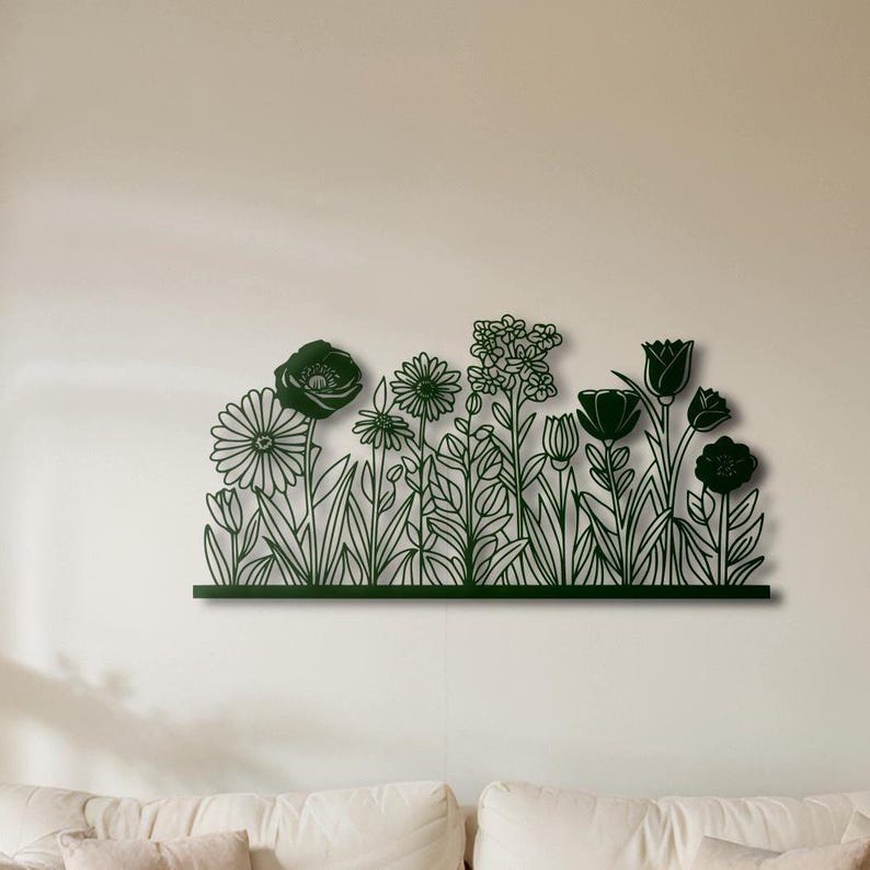 May include: A dark green metal wall art piece depicting a stylized field of flowers. The artwork features various flower shapes, including daisies, tulips, and other blooms, with detailed outlines and a dark green finish. The piece is mounted on a wall.