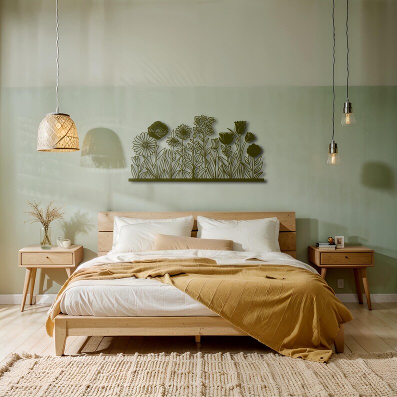 May include: A bedroom scene featuring a wooden bed with white bedding and a mustard-colored throw blanket. Above the bed is a metal floral wall art piece. The room has light green walls, wooden nightstands, and a woven rug.