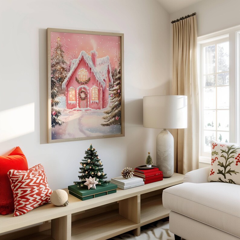 May include: A framed watercolor painting of a pink gingerbread house covered in snow, with a wreath on the door. The artwork is displayed above a wooden bench with Christmas decorations, including a small tree and decorative boxes. Red and white pillows add color.