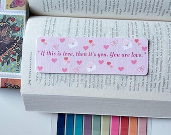 May include: A pink and white bookmark with a pink heart border and the text "If this is love, then it's you. You are love."