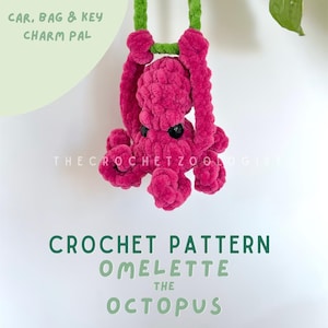 May include: A handmade pink crochet octopus charm with black eyes, suspended by a green cord. The text "CAR, BAG & KEY CHARM PAL" and "CROCHET PATTERN OMELETTE THE OCTOPUS" are also visible.