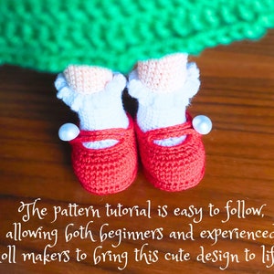 May include: A pair of red crocheted doll shoes with white trim and pearl accents. The shoes are on a wooden surface.