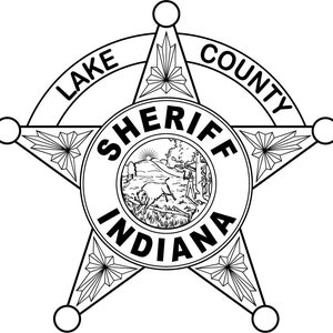 May include: Black and white illustration of a sheriff's badge with a five-pointed star. The badge has the words "LAKE COUNTY SHERIFF INDIANA" around the star.