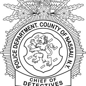 Op de afbeelding: Zwart-wit politielogo met een adelaar, sterren en een leeuw. De tekst luidt "POLICE DEPARTMENT. COUNTY OF NASSAU. N.Y." en "CHIEF OF DETECTIVES". De badge heeft een gedetailleerd ontwerp met een schildvorm.