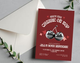 May include: Red invitation card with white text that says "She's the Cherry on Top" with a graphic of two cherries. The text below says "You're invited to Jill's 80th Birthday" with the date, time, and RSVP information.