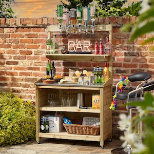 May include: A wooden outdoor bar with a metal countertop and a brick wall background. The bar has shelves, a neon "BAR" sign, and liquor dispensers. Various bottles, glasses, and bar accessories are visible. A black bar stool with a lei is on the right.