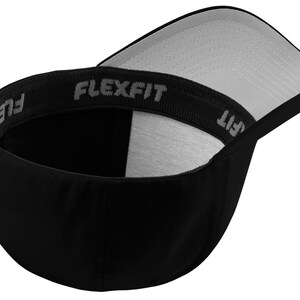 Może przedstawiać: Czarna czapka bejsbolowa Flexfit z zakrzywionym daszkiem i szarym wnętrzem. Wewnętrzna opaska ma logo Flexfit w szarych literach. Czapka została zaprojektowana z dopasowanym krojem.