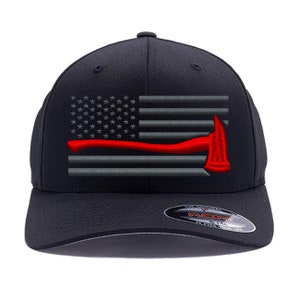 Puede incluir: Gorra de béisbol negra con una bandera estadounidense gris y roja y un hacha roja bordada en la parte delantera. La gorra tiene una visera negra y una correa ajustable negra.
