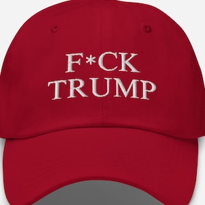 以下が含まれることがあります： フロントパネルにF*CK TRUMPと白の刺繍が施された赤い野球帽。帽子は構造化されたクラウン、カーブしたつば、中央上部にボタンを備えています。刺繍は中央に配置され、太字で読みやすいフォントスタイルが使用されています。